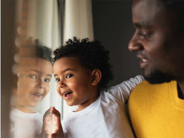Parent and child looking out a window