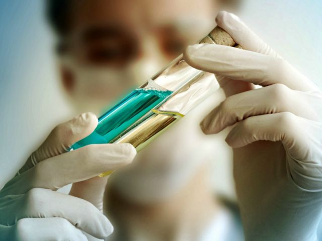 Photo of scientist inspecting vials