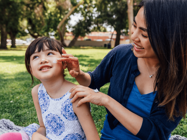 Mother applying sunscreen to daughter