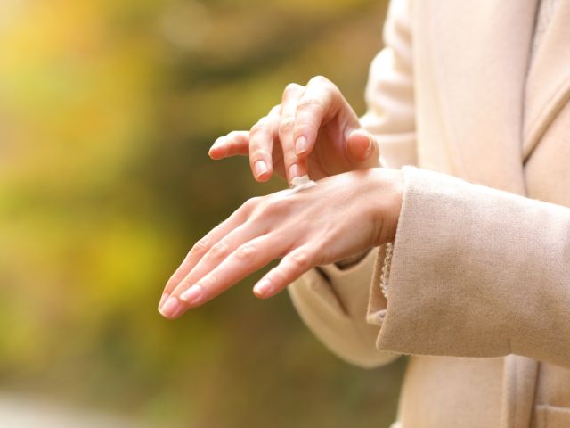 Woman rubbing lotion on skin