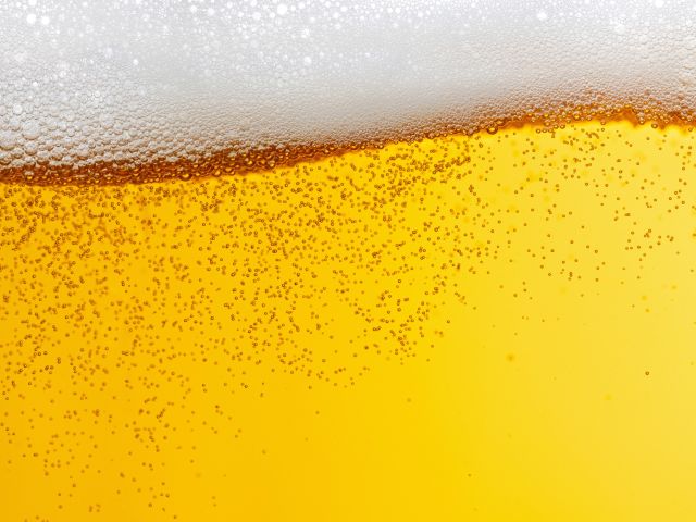 Golden beer with a frothy white head and visible bubbles.