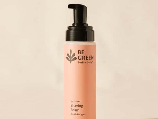 Natural shaving foam in a pink bottle with a black pump top and logo.