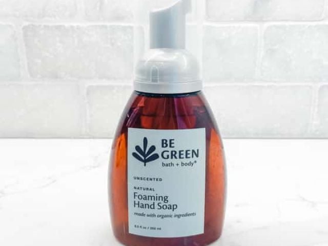 Brown bottle of unscented foaming hand soap on a light marble surface.