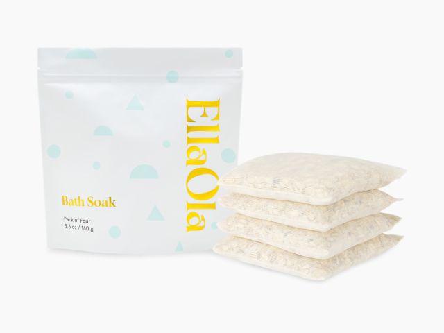 White pouch labeled "EllaOla Bath Soak" beside four individually packed bath soak sachets.