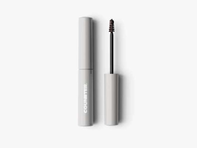 Gray mascara tube with a cap removed, revealing the application brush.