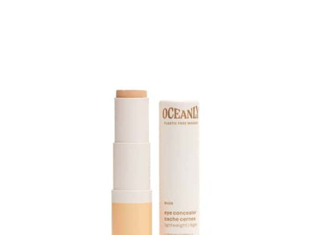 A stick eye concealer in beige packaging with a separate white container.