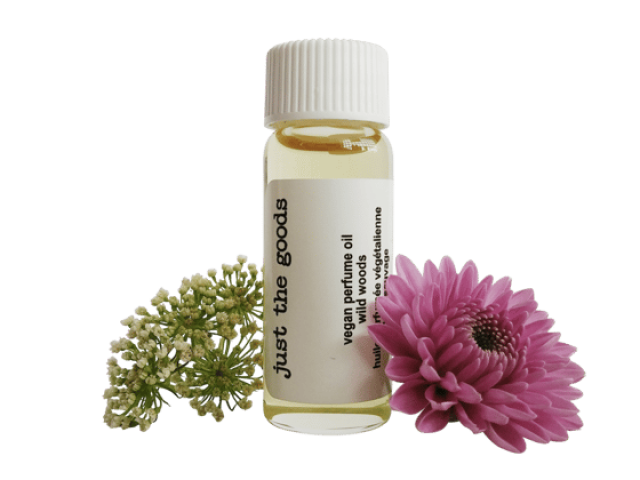 Small glass bottle of vegan primrose oil surrounded by green and pink flowers.