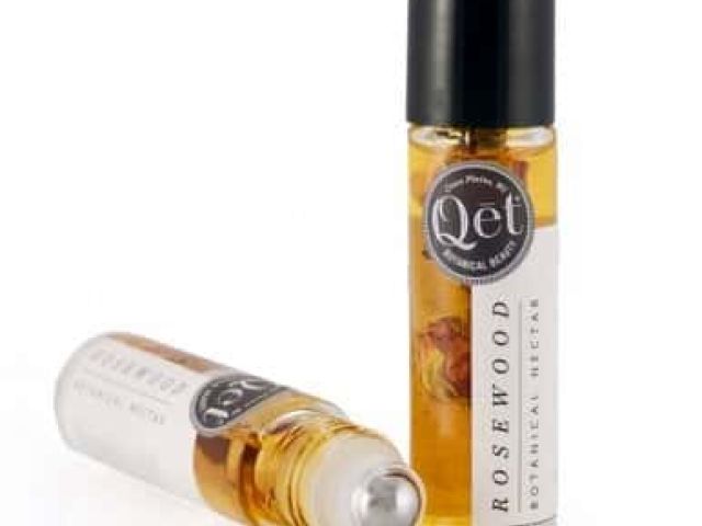 Two glass roll-on bottles of rosewood botanical nectar, one upright, one tilted.