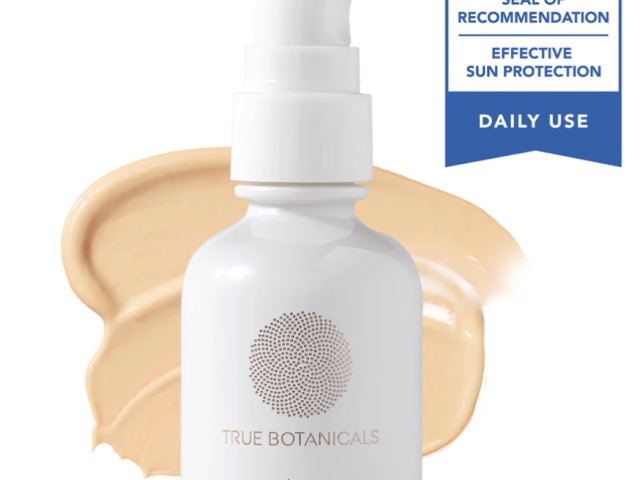 White pump bottle of sunscreen with a tan cream swatch and a seal of recommendation.