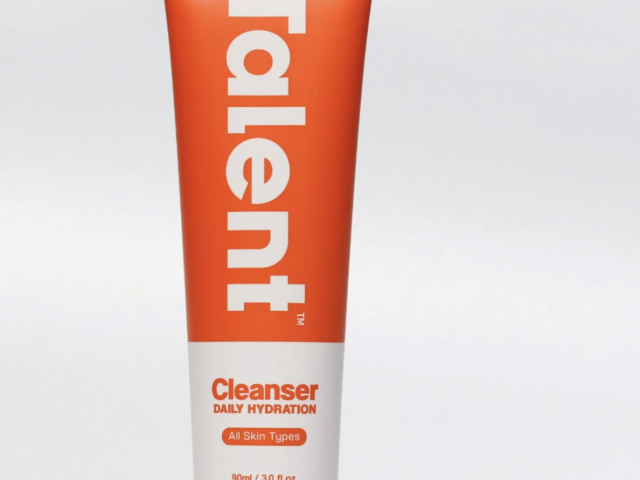 Photograph of orange and white "Talent" cleanser tube labeled Daily Hydration on white background
