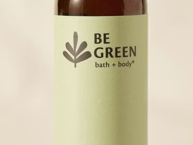 Photograph of brown bottle with black cap and green BE GREEN hair oil label.