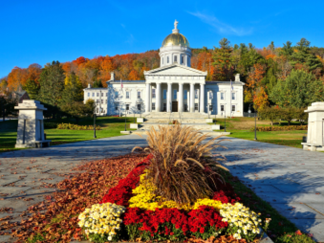 Photograph: Vermont State House with gold dome, autumn foliage and flowers