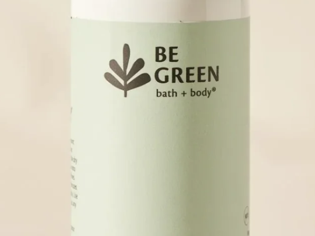 Photograph of a pale green Be Green dry shampoo bottle with silver cap on beige background.