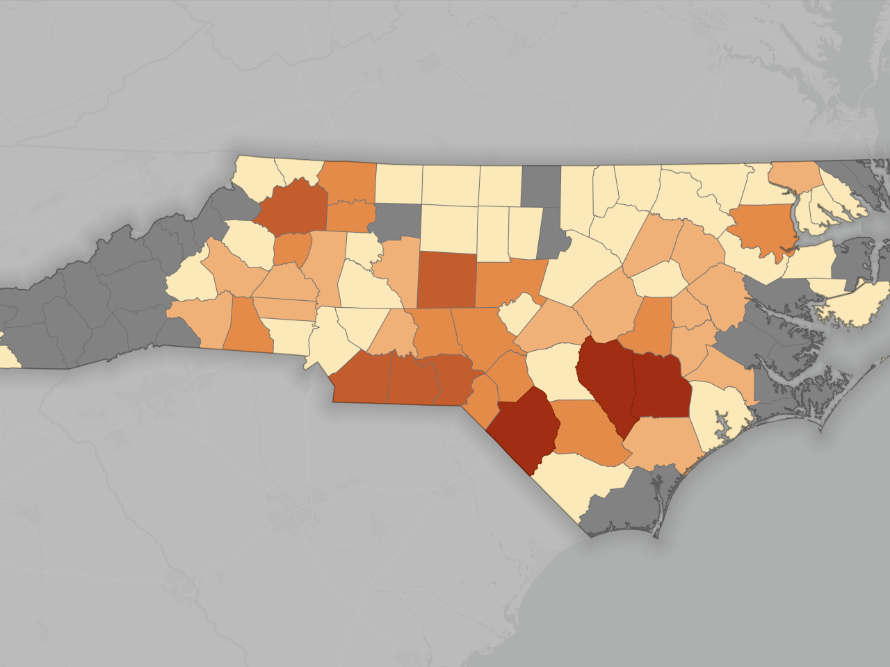 Map of North Carolina counties shaded from beige to dark red, some counties gray