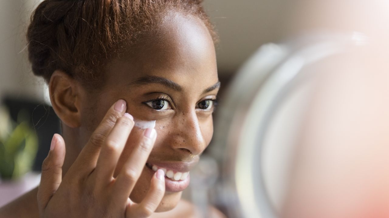 Woman putting on face cream