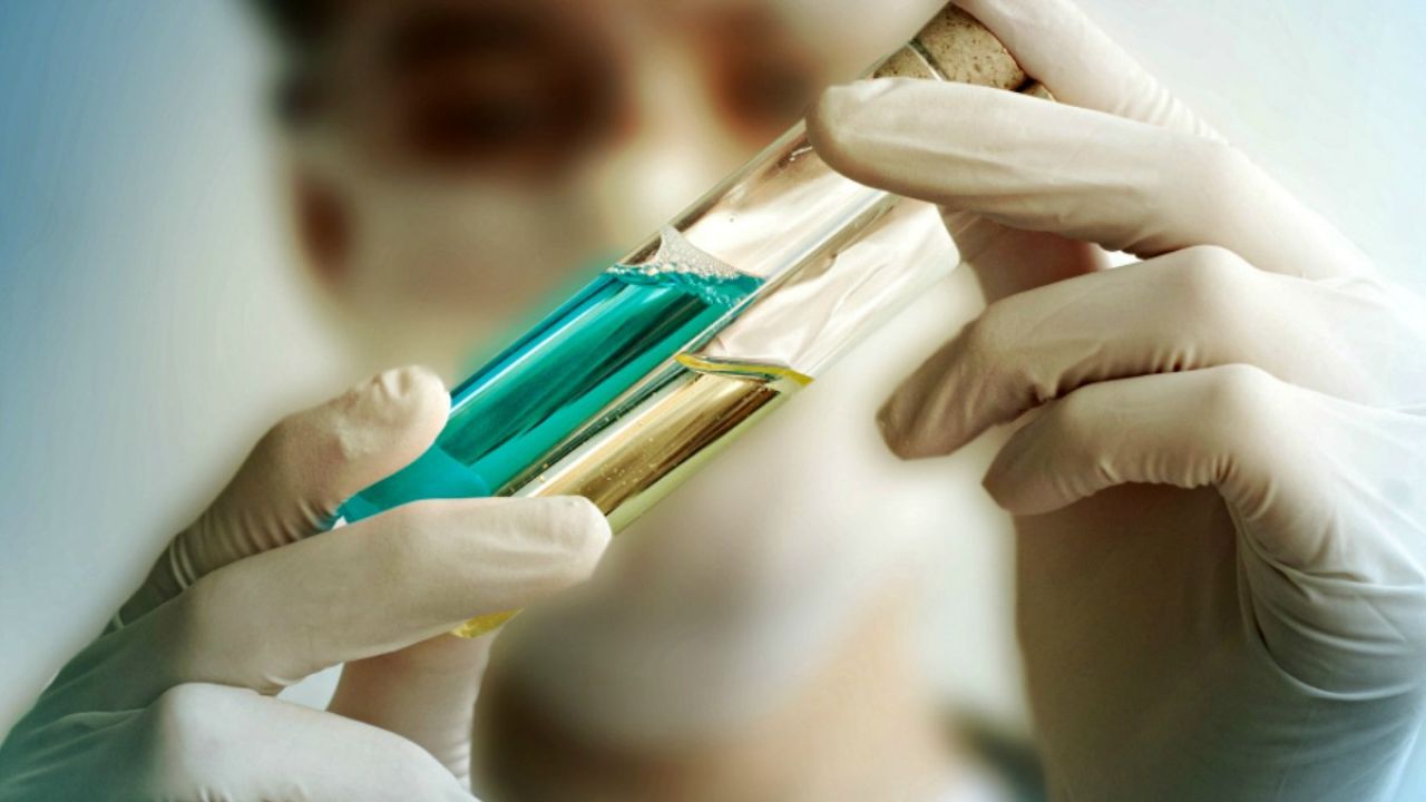 Photo of scientist inspecting vials