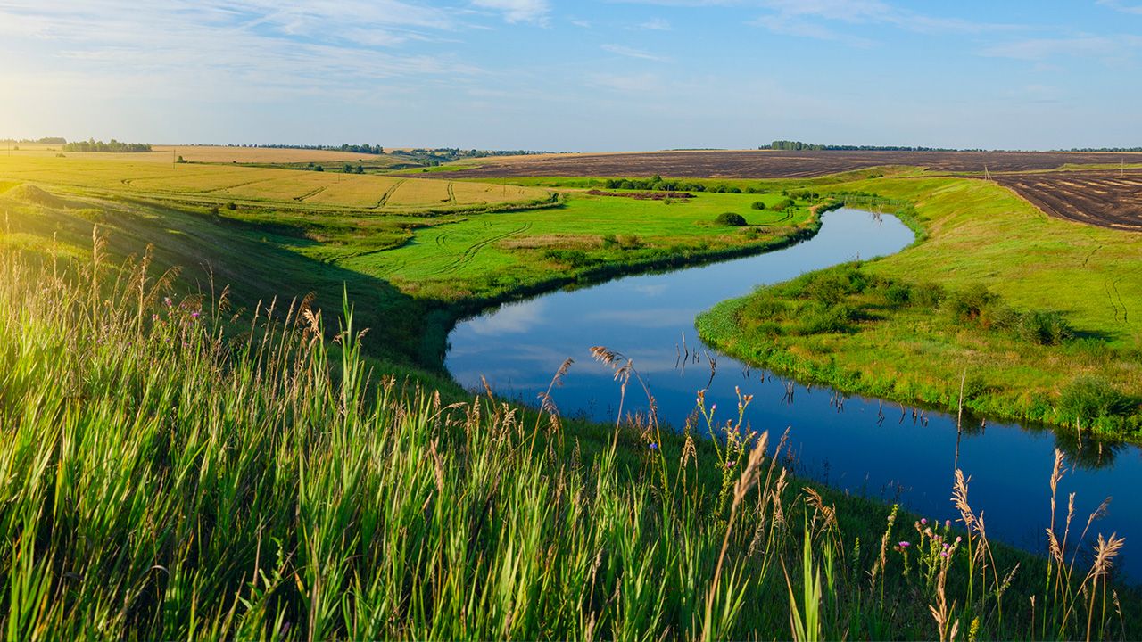 Photo of a farm near a river