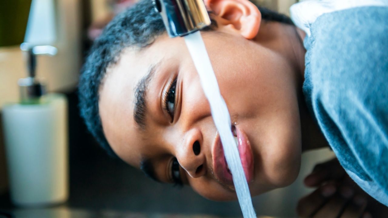 Child drinking from faucet