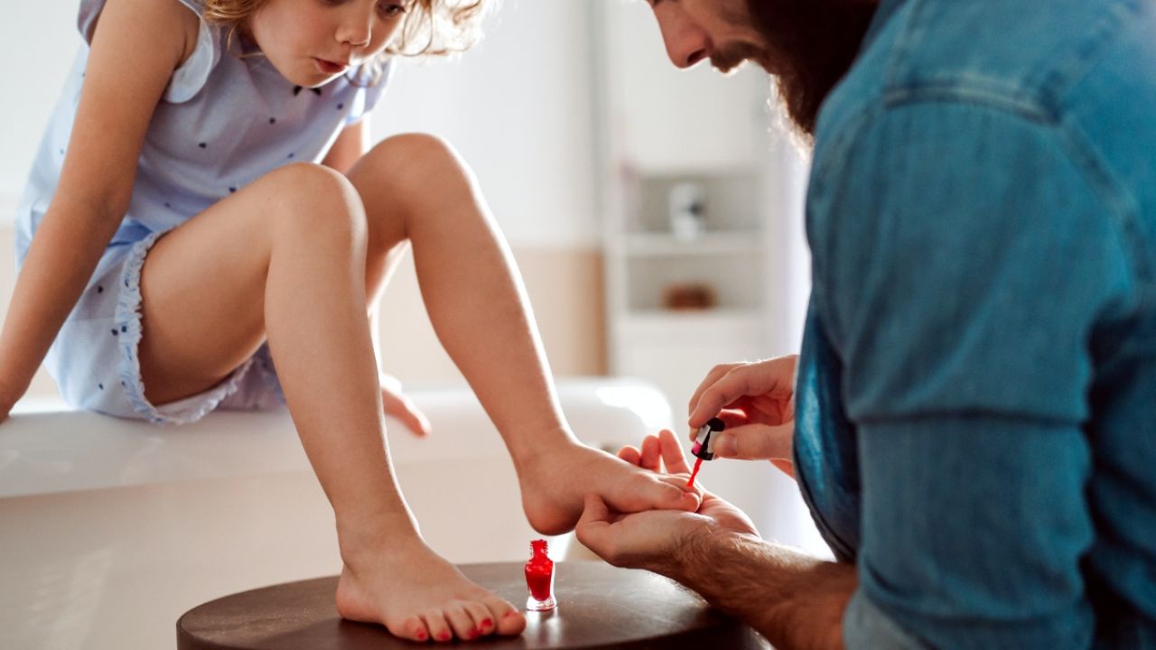 Father applying daughter's nail polish