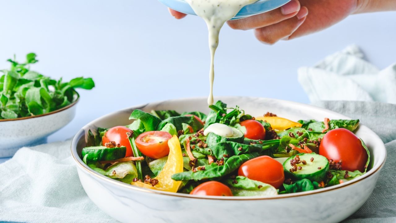 Dressing being poured over a salad