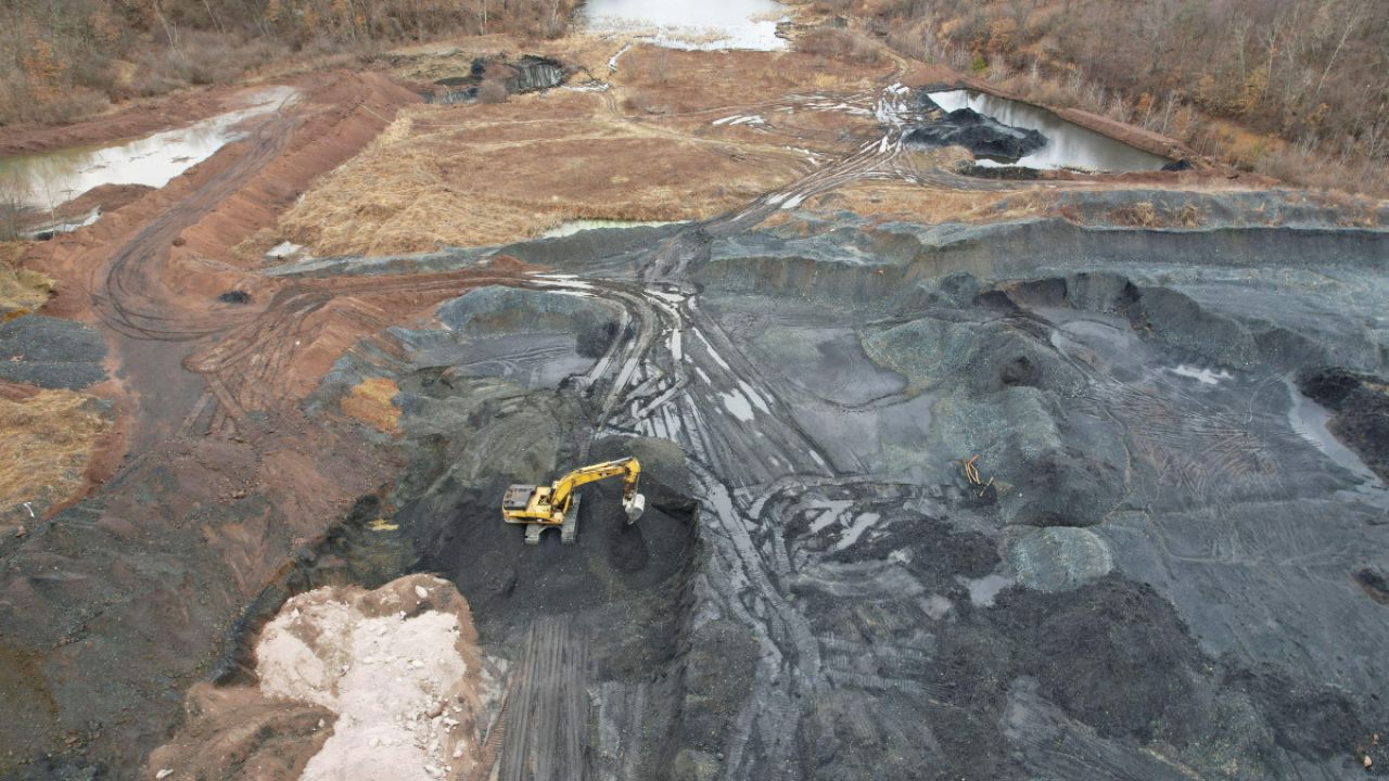An excavator prepares waste coal materials to be transported from a site to the Scrubgrass Power Plant in Kennerdell, Pennsylvania