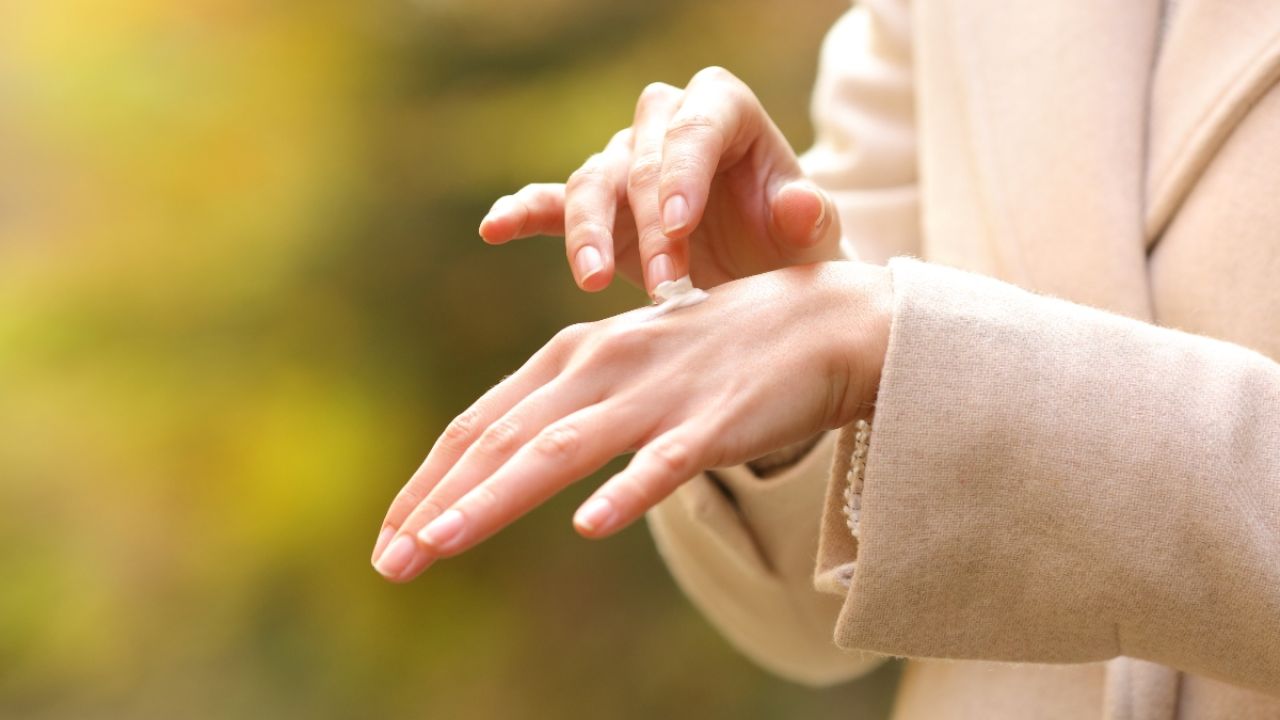 Woman rubbing lotion on skin