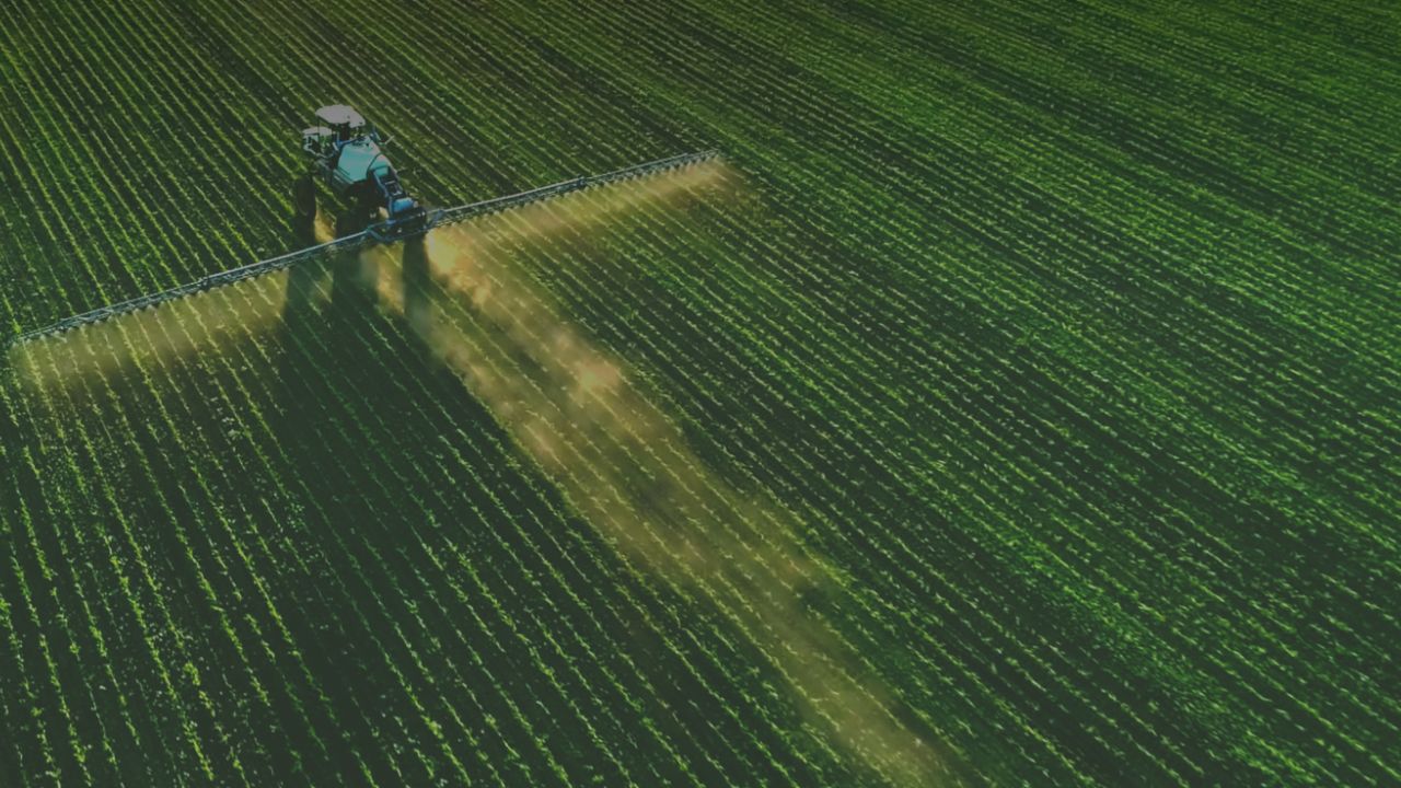 Tractor spraying pesticide on field