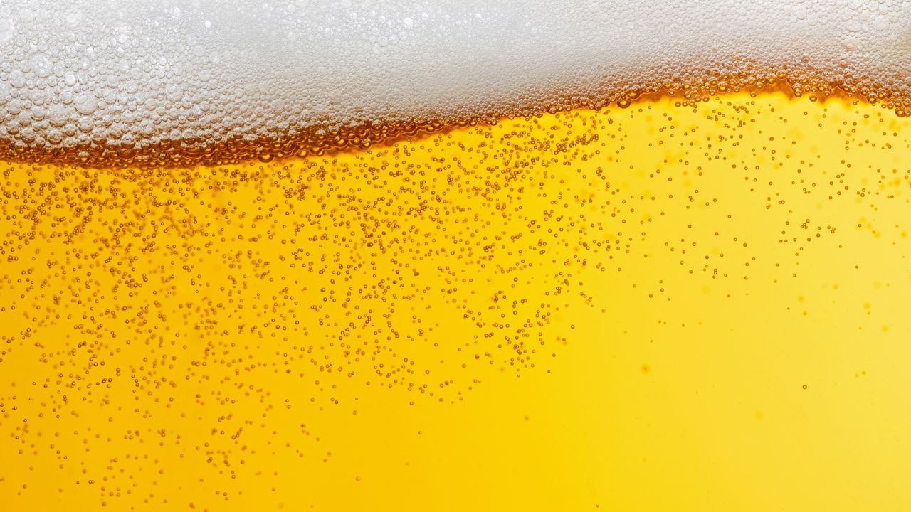 Golden beer with a frothy white head and visible bubbles.