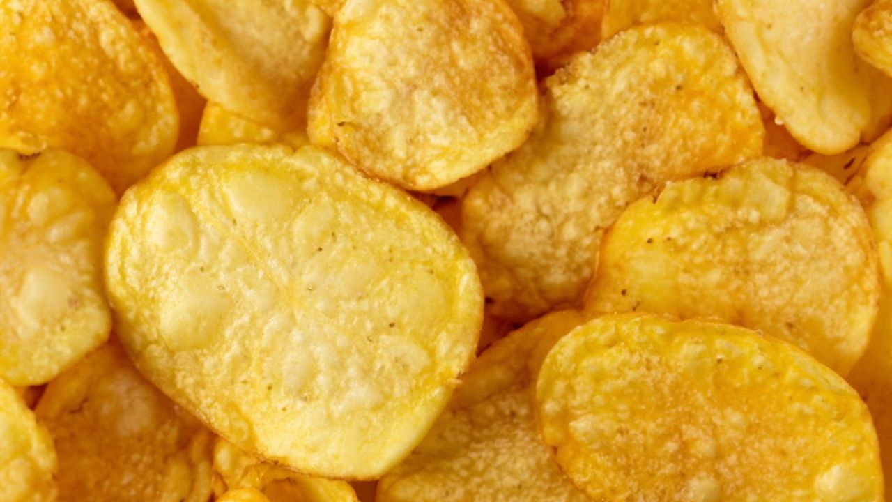 Close-up photograph of golden, salted potato chips